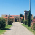 De oprit naar Salvapiano Holiday ranch in Italië, omgeven door planten en bloemen.