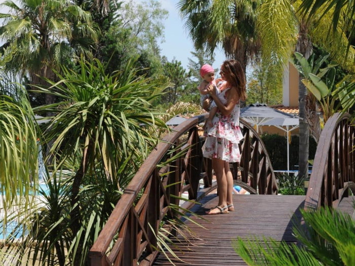 Mevrouw met baby op brug bij zwembad