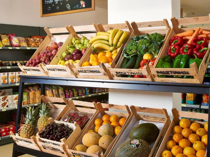 Groenten en fruit in houten kistje bij supermarkt