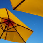 Hoofdfoto vakantie musthaves parasols met blauwe lucht