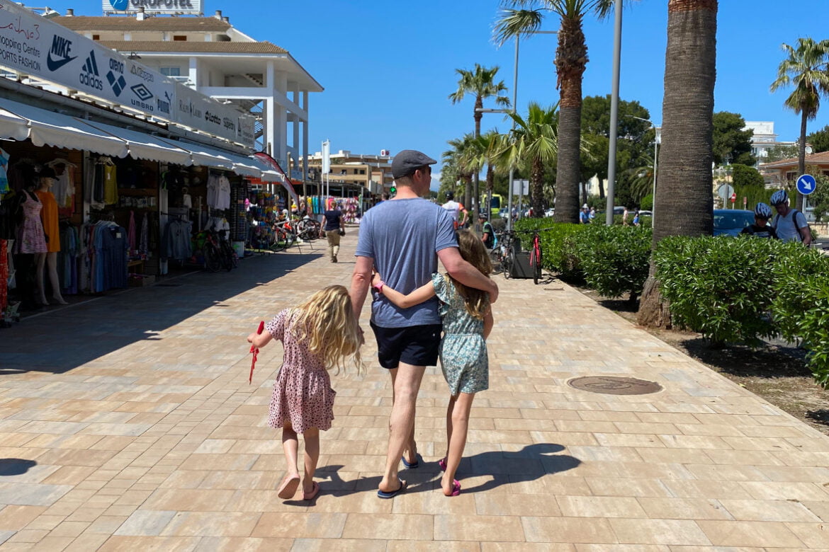 Vakantie met kinderen: 6 tips voor een geweldige gezinsvakantie! Vakantie met kinderen gezin loopt over boulevard met palmbomen